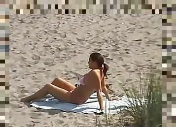 Woman on a beach gives a handjob to a lucky fellow