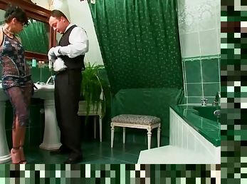 Bathroom attendant cleans up as mistress watches