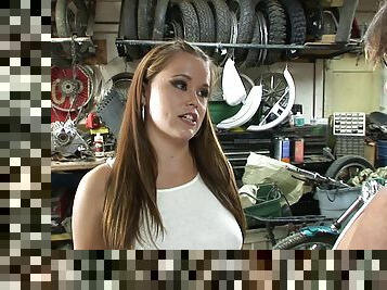 In the garage a slutty biker girl is double penetrated by two guys