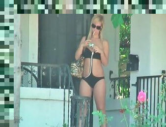 Chick walks in her swimsuit and smokes outdoors