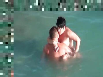 Mature couple boldly fucks in the ocean