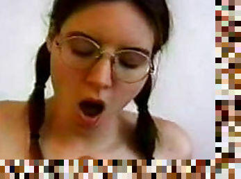 Pigtailed brunette in glasses is masturbating