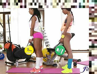 Ebony babes enjoy poking each other's wet pussies on the gym floor