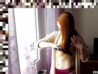 Naked redhead teen brushing her hair at home