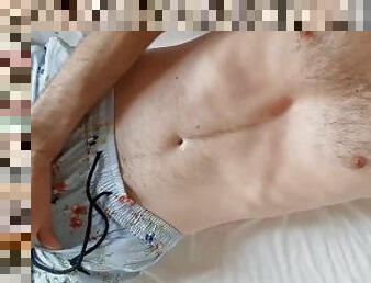 a young fit hairy guy in pajamas jerks off in his bed