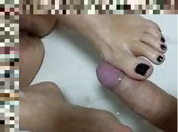 Gostosa de unhas pretas faz footjob e leva gozada no pé